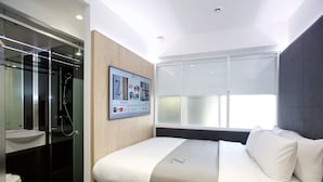 A modern hotel room with a large bed, a mounted TV, a glass shower enclosure, and a large window. - The Z Hotel Tottenham Court Road (London)