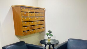 Ein Zimmer mit zwei schwarzen Ledersesseln, einem kleinen runden Tisch und einem Holzschrank mit beschrifteten Schubladen.