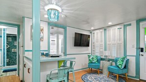 Une cuisine avec des meubles de couleur turquoise, un plan de travail en bois et un tapis rond bleu et blanc.