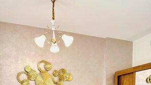 Une chambre à coucher avec un grand lit, une tête de lit en bois, une table de chevet avec une lampe et un miroir.