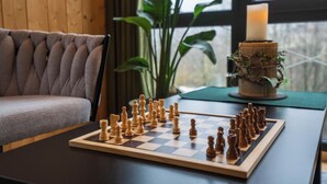 A chessboard on a table with a candle and a plant beside it. - Taunus Tinyhouse (Weilrod)