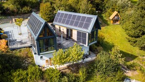 A modern house with a sloped roof and solar panels. - Taunus Tinyhouse (Weilrod)