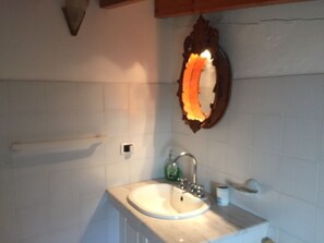A bathroom with a sink, a mirror, and a towel rack.