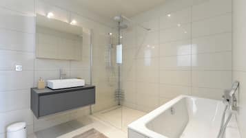 Un baño moderno con una bañera grande, una ducha con mampara de vidrio, un tocador con lavabo y un espejo.