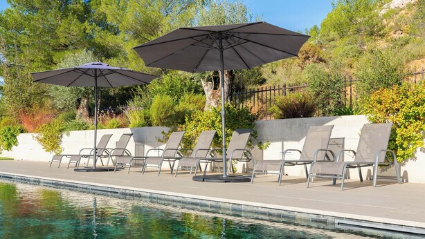 A clear swimming pool with lounge chairs and umbrellas.