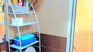 A compact bathroom with a white toilet, a small sink, and a shelf with toiletries. - Entire private studio with everything you need for a pleasant stay. (Rabat)