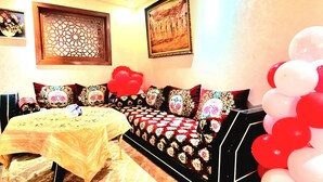 A room with a sofa set, a table with a tablecloth, and a wall with framed artwork. - Entire private studio with everything you need for a pleasant stay. (Rabat)