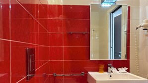 A bathroom with red tiles, a white sink, a mirror, and a towel rack. - Casa Vacanze Fardella Centrale (Trapani)