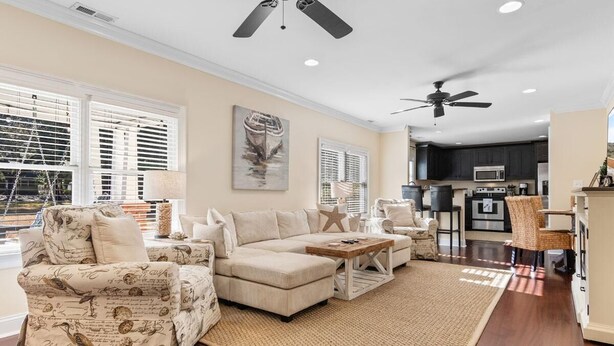 A spacious living room with a sectional sofa, a coffee table, and a large window with blinds. - The Red Door House in Historic Georgetown (Georgetown)