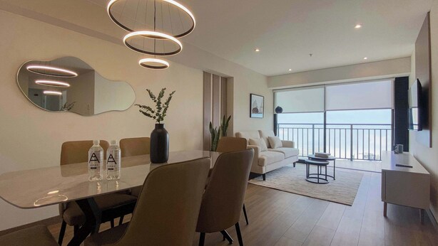 A modern living room with a dining area, large windows, and a view of the sea. - w* | Pleasant 3BR w/ Balcony in San Isidro (Lima)