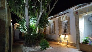 Un cortile con una bicicletta, un albero e un edificio con persiane.