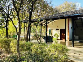 A covered outdoor area with a patio, seating, and a view of a building.