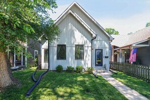 A single-story house with a gabled roof, a front porch, and a small front yard.