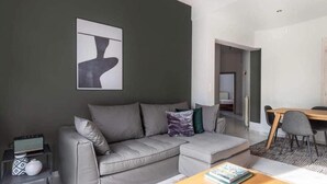 A modern living room with a grey sofa, a coffee table, and a painting on the wall. - Acropolis view (Athens)