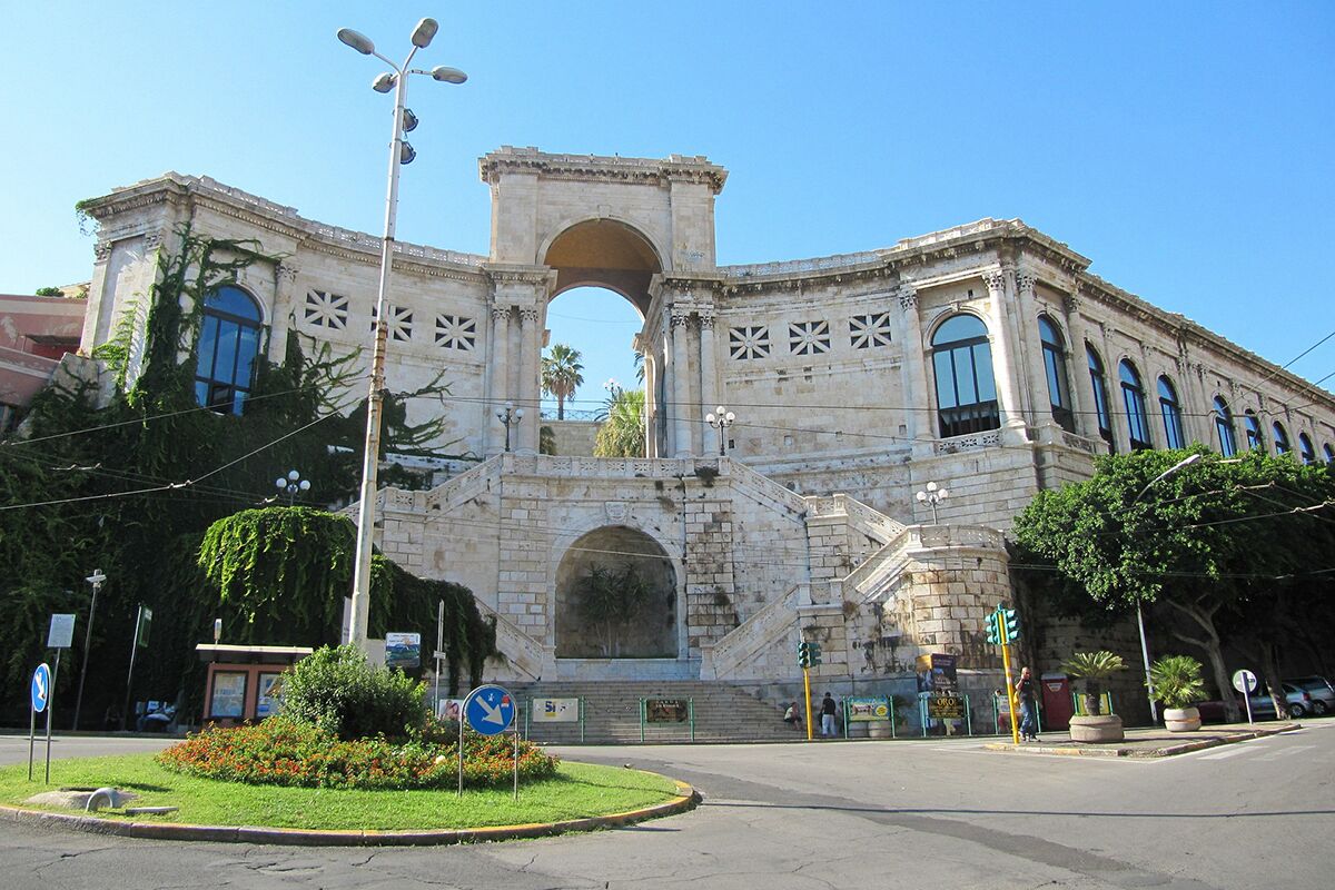 Un bâtiment historique doté d’une arche centrale, de grandes fenêtres et d’une façade symétrique.