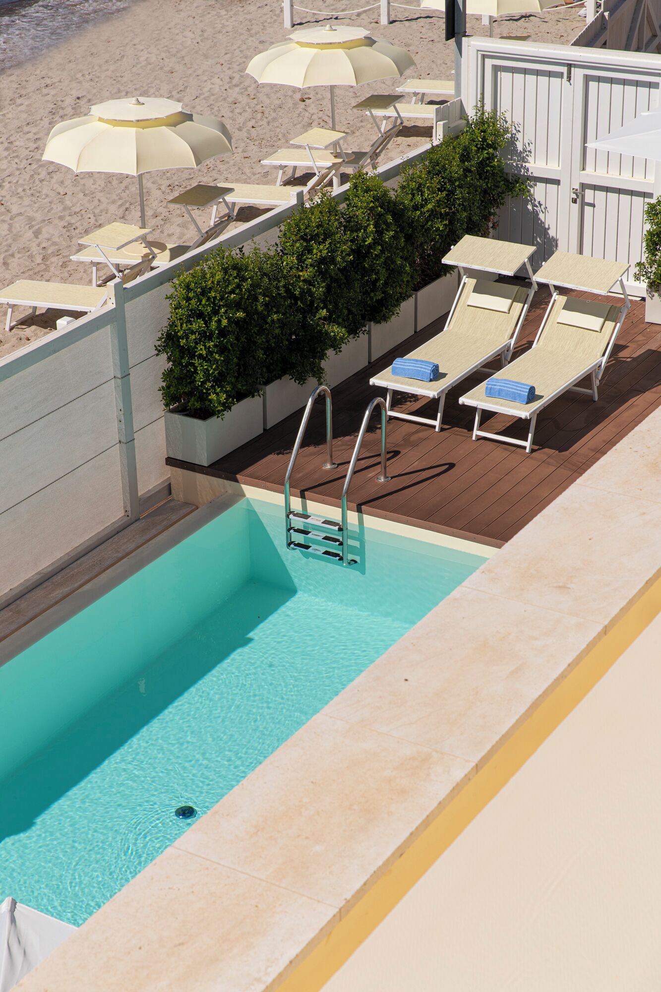 Zona de piscina al terrat amb gandules i ombrel·les.