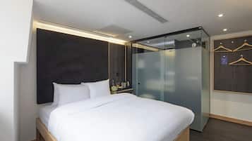 Ein modernes Hotelzimmer mit einem großen Bett, einem Kleiderschrank und einem Spiegel.