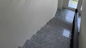 A staircase with a floral garland and a framed picture on the wall. - Deluxe 3 Br Happy House - Novaworld PT (Tien Thanh)