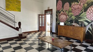 A checkered floor, a wooden table, a cabinet, and a door with a glass panel. - Domaine de l'Aven (Villeneuve-Minervois)