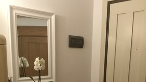 A bathroom with a white vanity, a mirror, a potted orchid, and a fruit bowl. - LOFT - TOLOMEI Residence - Sacile (Sacile)