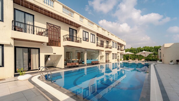 Ein Hotel mit Schwimmbad, Außenbereich und Balkonen.