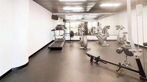 Une salle de sport équipée de tapis de course, de vélos d’appartement et d’appareils de musculation.
