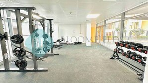 Een sportschool met krachthonderdelen, een squatrek en dumbbells.