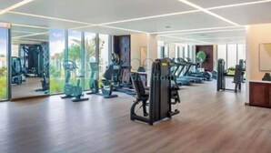 A modern gym with cardio machines, free weights, and mirrored walls.