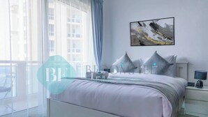 Une chambre à coucher moderne, avec un lit, une table de chevet, une œuvre d’art accrochée au mur et une fenêtre ornée de rideaux légers.
