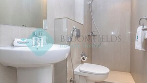 A bathroom with a white sink, toilet, and shower. - Bloomfields Iconic 2BR & Maid Address Beach Resort (Fujairah)