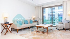 A modern living room with a sofa, a coffee table, and a side table. - Bloomfields Iconic 2BR & Maid Address Beach Resort (Fujairah)