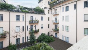 Een binnenplaats met meerdere appartementencomplexen, elk met balkons en een aantal met beplanting.