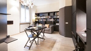 Een moderne woonkamer met een eethoek, een boekenkast en een groot raam.