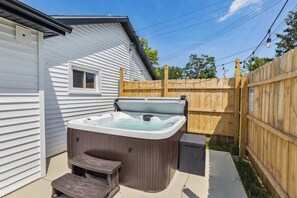 A hot tub with a wooden deck and a small window on a house. - Vermilion Getaway - Hot Tub • Game Room • Patio (Vermilion)