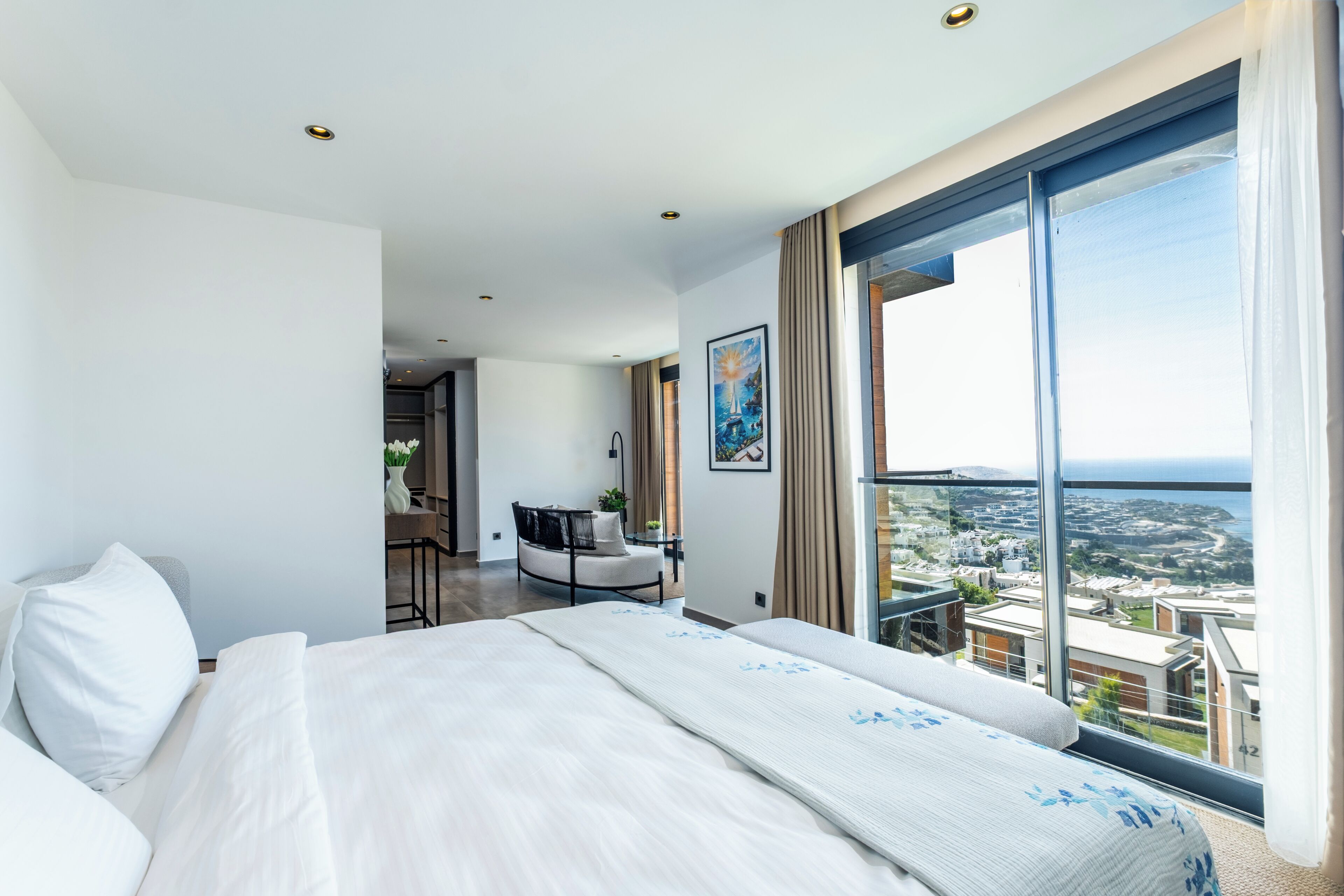 Une chambre d’hôtel moderne dotée d’un grand lit, d’un balcon avec vue sur la ville et d’un coin repas.