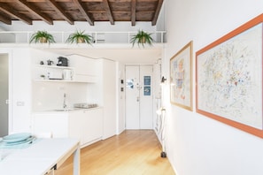 Una cocina moderna con armarios blancos, techo de madera y dos plantas en macetas.