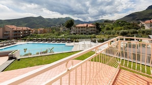 Un hôtel doté d'une piscine, d'un espace extérieur aménagé et offrant une vue sur les montagnes.