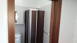 Un baño con ducha, inodoro y lavamanos.