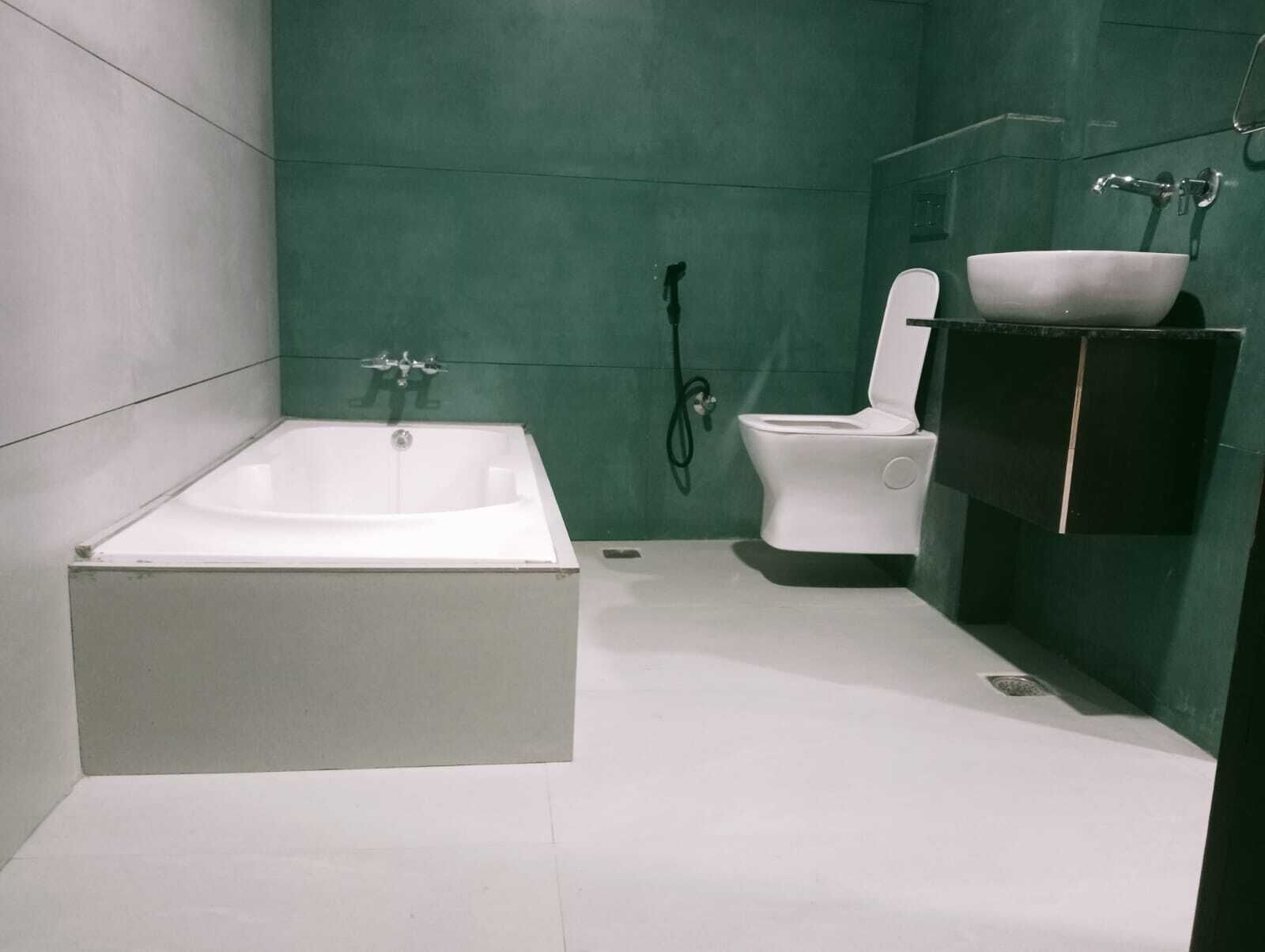 Un baño moderno con una bañera independiente, un inodoro y un lavabo con espejo.