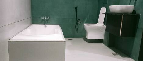 Un baño moderno con una bañera independiente, un inodoro y un lavabo con espejo.