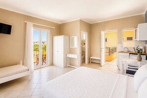 A bedroom with a large bed, a wardrobe, a desk, and a bathroom.