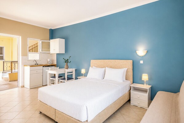 Un dormitorio con cama, mesitas de noche, escritorio y silla.