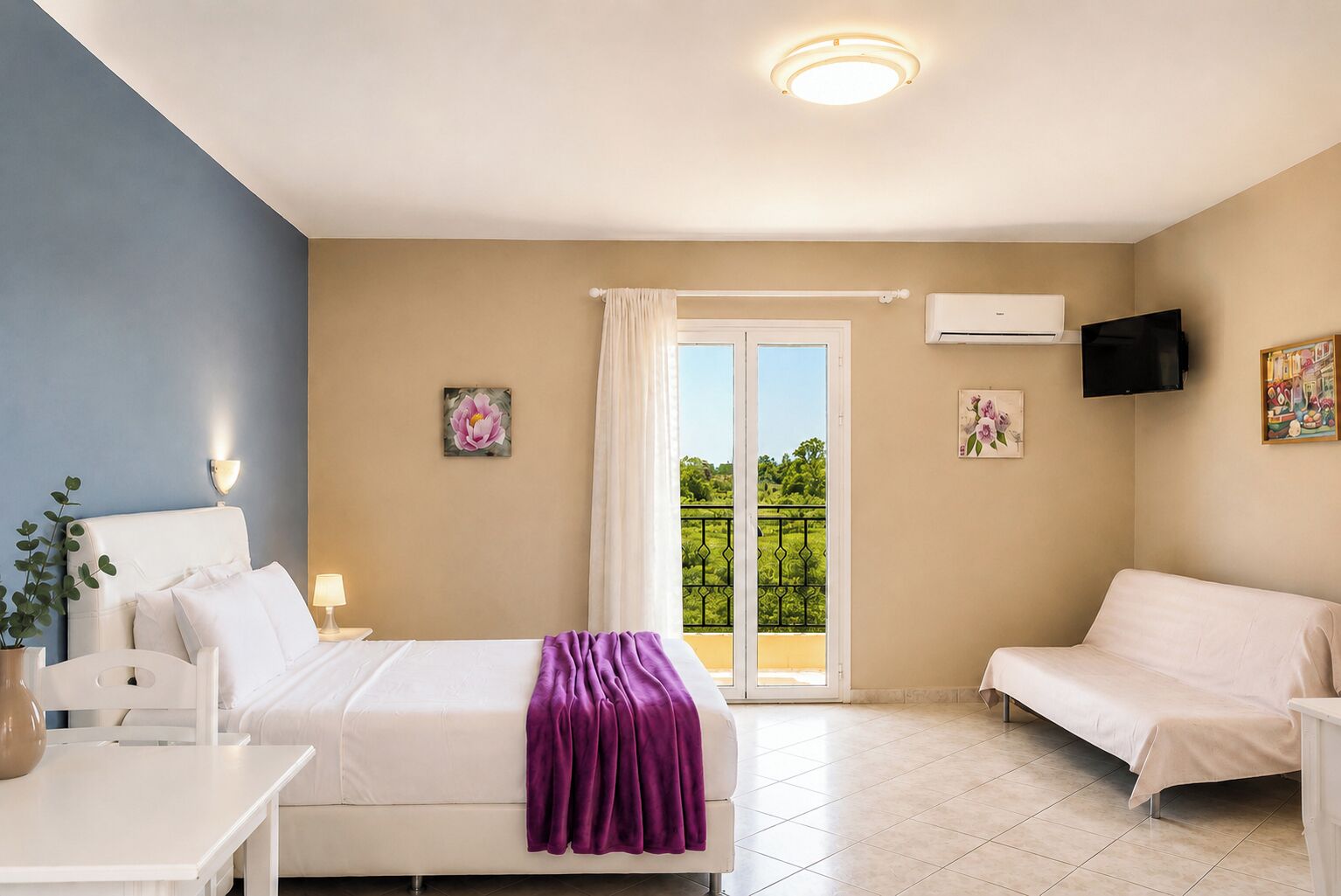 Ein Hotelzimmer mit Bett, Sofa, Fernseher und einem Balkon mit Blick.