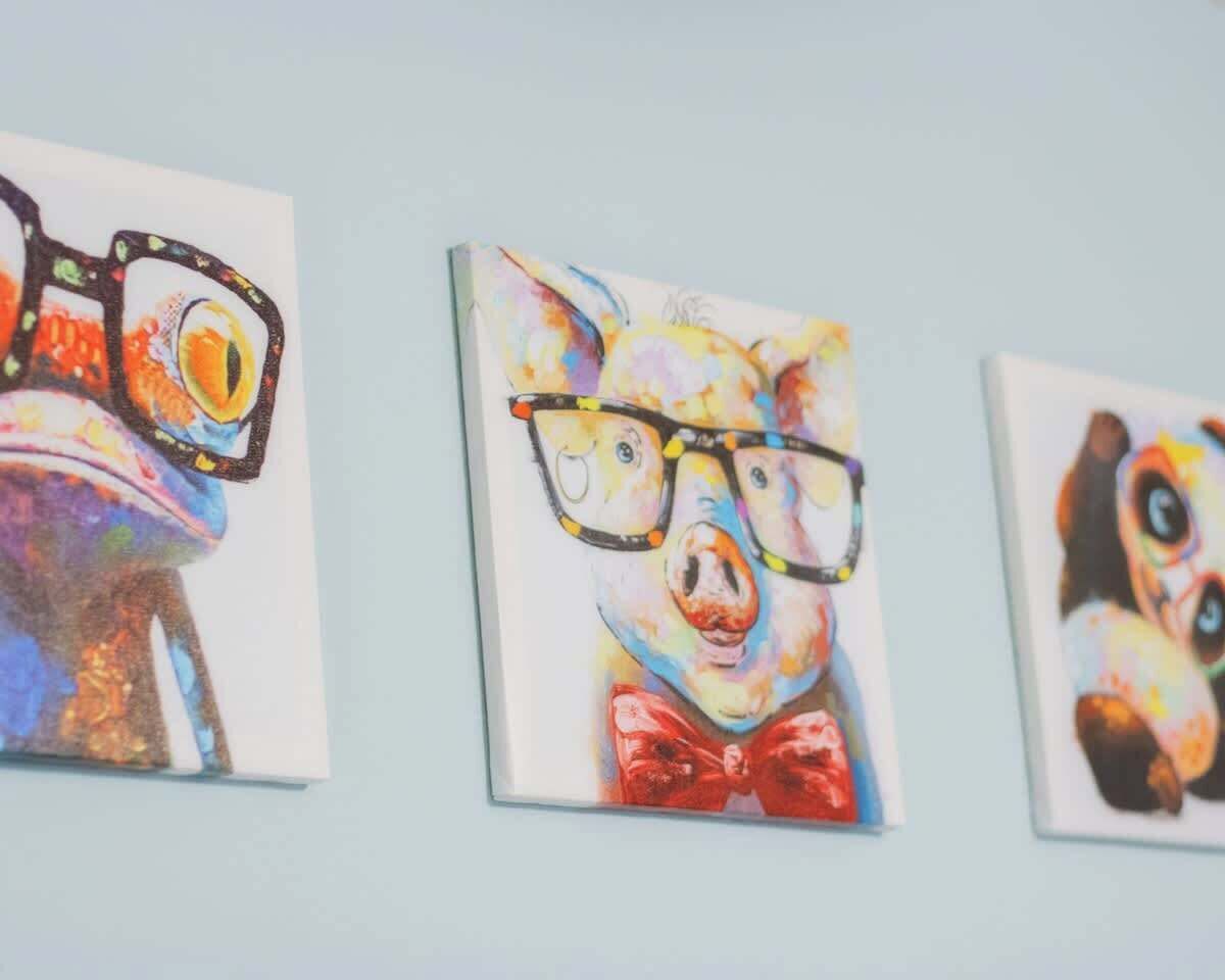 Trois œuvres d’art encadrées sont accrochées au mur.
