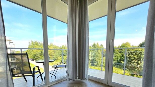 A balcony with a view of a road and greenery. - Apartament Luxe w Kołobrzegu - 365PAM (Kolobrzeg)