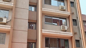 A multi-story building with air conditioning units on each floor, a sign for 'Divine Residency' at the ground level, and a metal gate in front. - Divine Residency (Panvel)