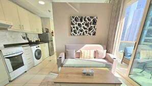 Un appartement moderne doté d’une kitchenette, d’un canapé et d’une grande fenêtre.