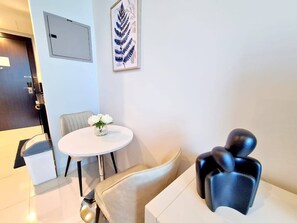 A modern room with a round table, a chair, a decorative plant, and a unique sculpture. - Sunrise Homes - Large Spacious  Studio in Business Bay (Business Bay)