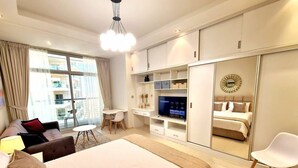 Une chambre d’hôtel moderne équipée d’un grand lit, d’un bureau, d’une télévision et d’une armoire.