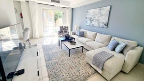 Una sala de estar moderna con un sofá, una mesa de centro y un cuadro abstracto grande en la pared.